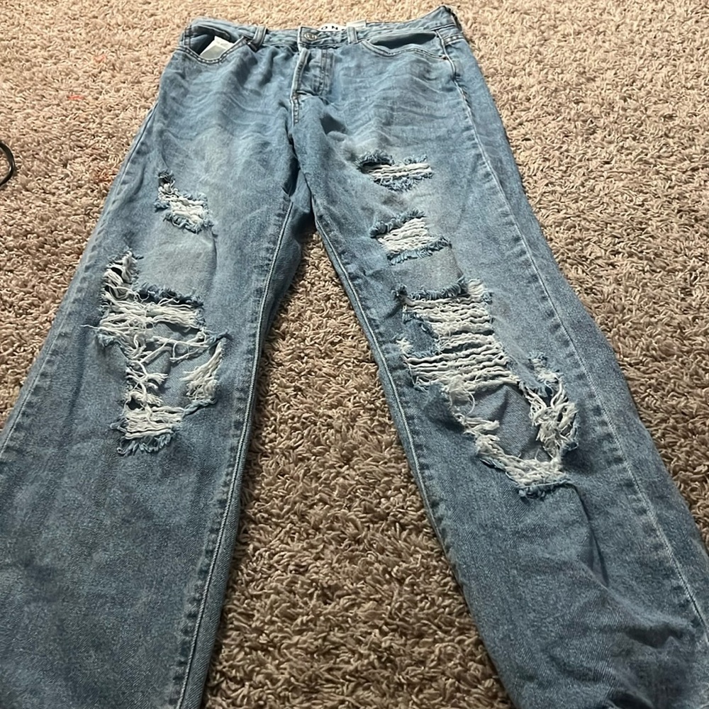Distressed straight legged blue jeans.